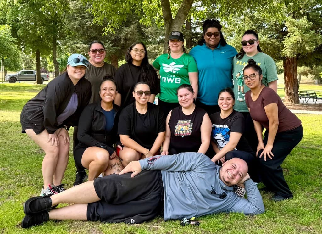 Forge Strength group members posing together outdoors on the grass